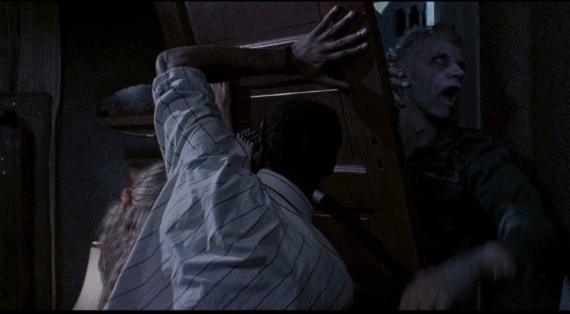 Ben (Tony Todd) attemptes to keep the zombies out in Night of the Living Dead (1990).