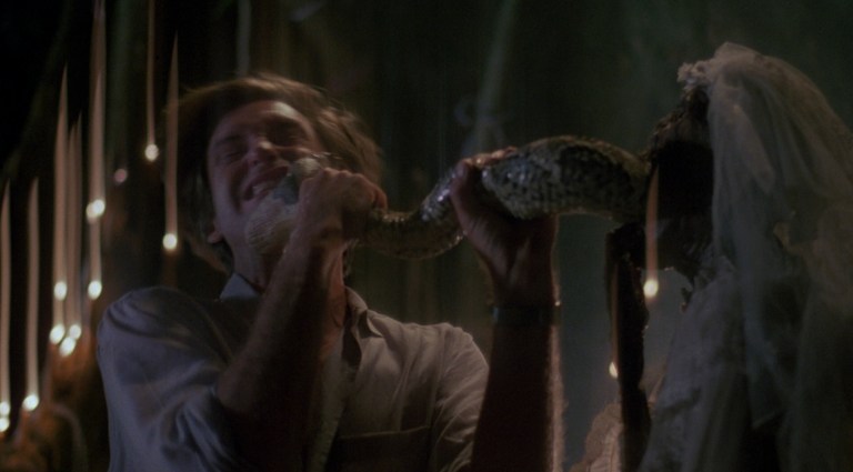 Bull Pullman bitten by a snake coming out of the mouth of a dead woman in The Serpent and the Rainbow (1988).