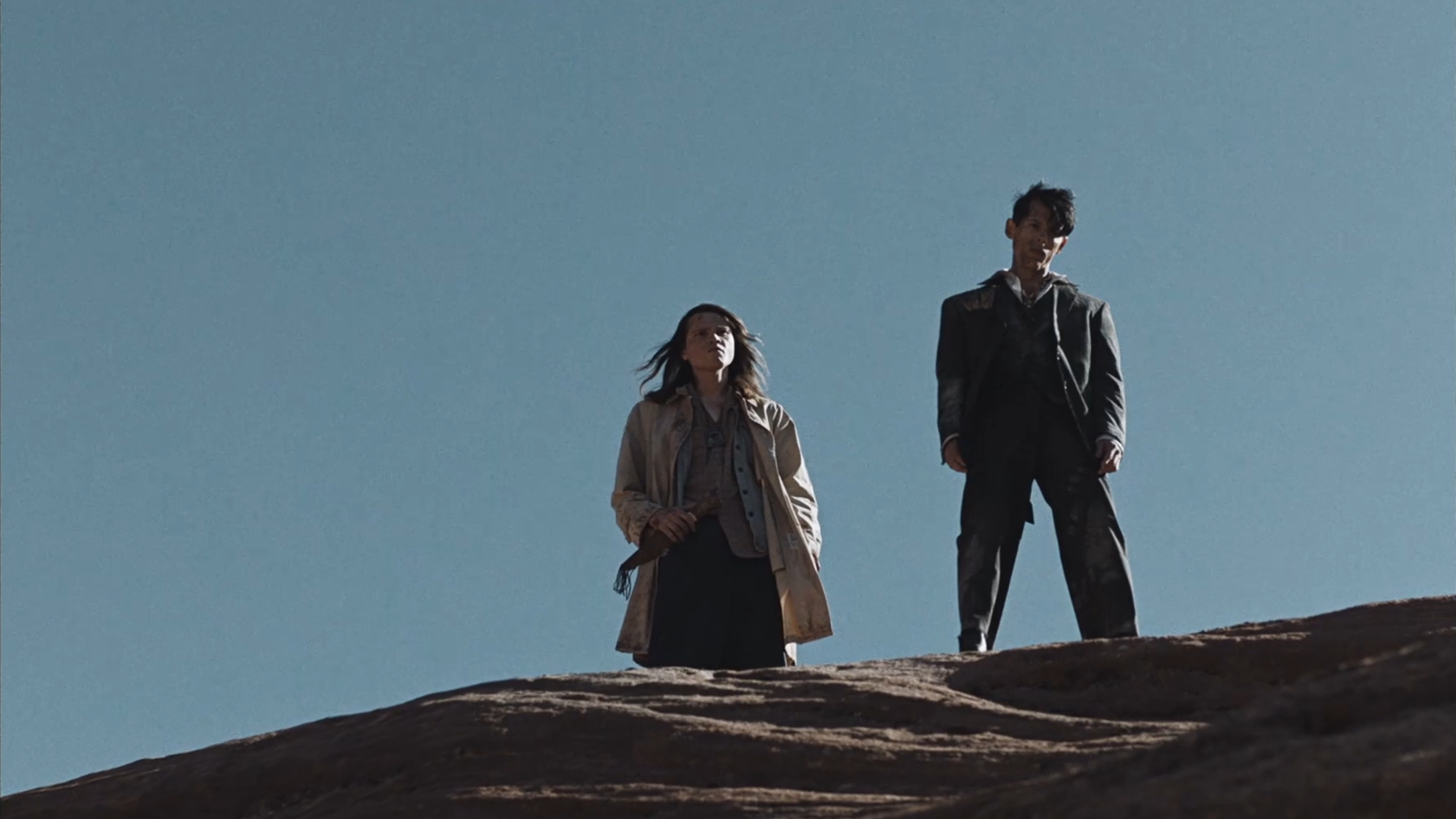 Two young men look down into the canyon in The Seeding (2023).