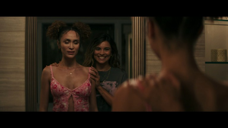 Nadia smiles as Zoe tries on a new top in Model House (2024).