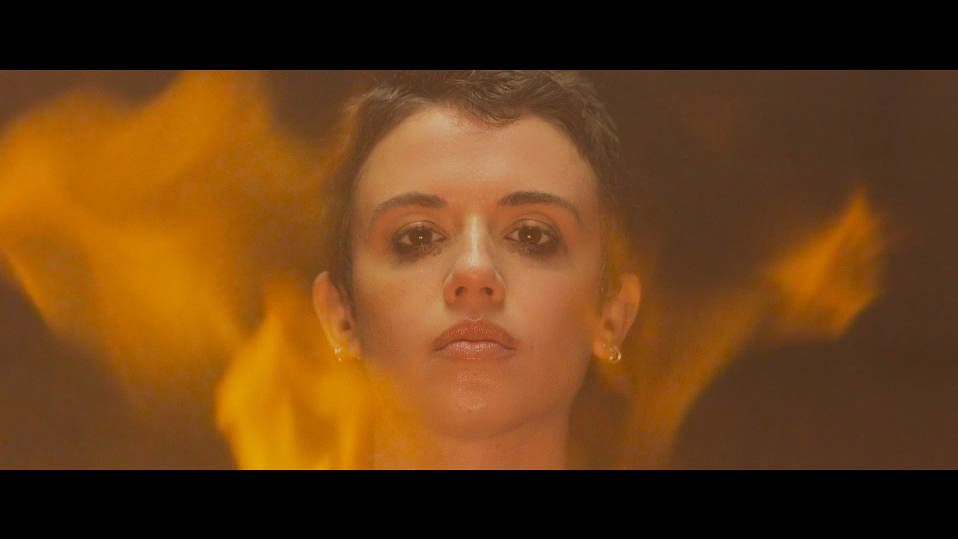 Bowie (Jenna Kanell) stands in front of flames in Faceless After Dark (2023).