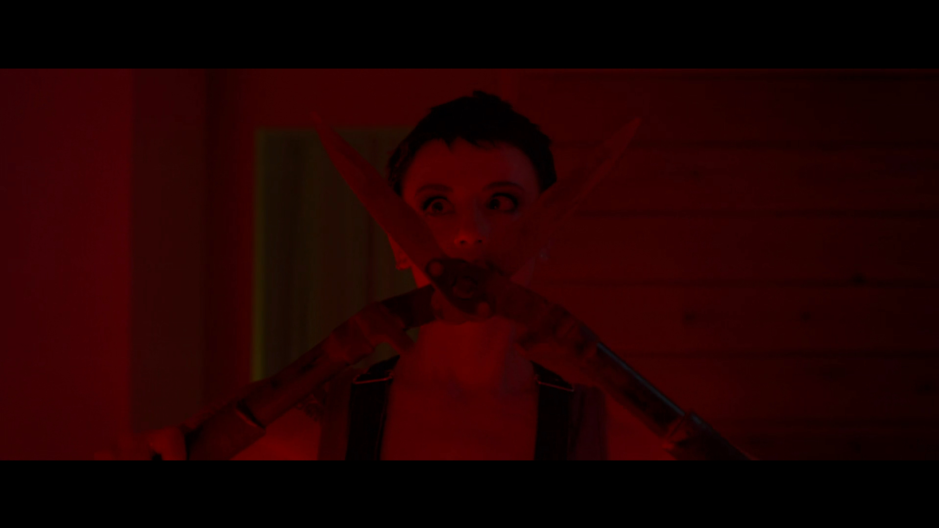 Bowie holds a pair of hedge shears in Faceless After Dark (2023).