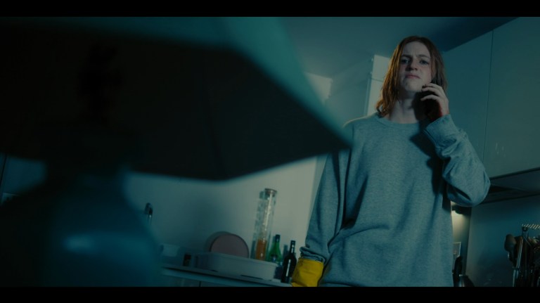 Dakota stares angrily at a lamp in Kill Your Lover (2023).