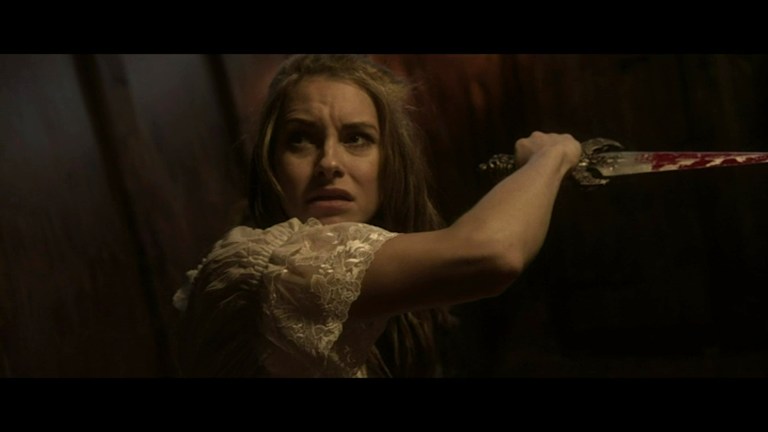 Elena holds a bloody knife in Ship of the Damned (2024).