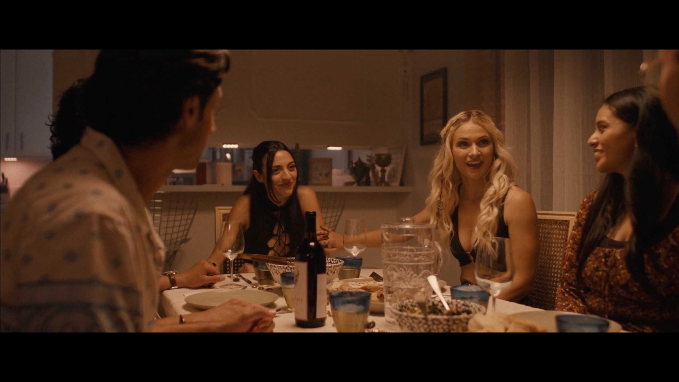 Celeste and her friends smile during dinner in Stupid Games (2024).