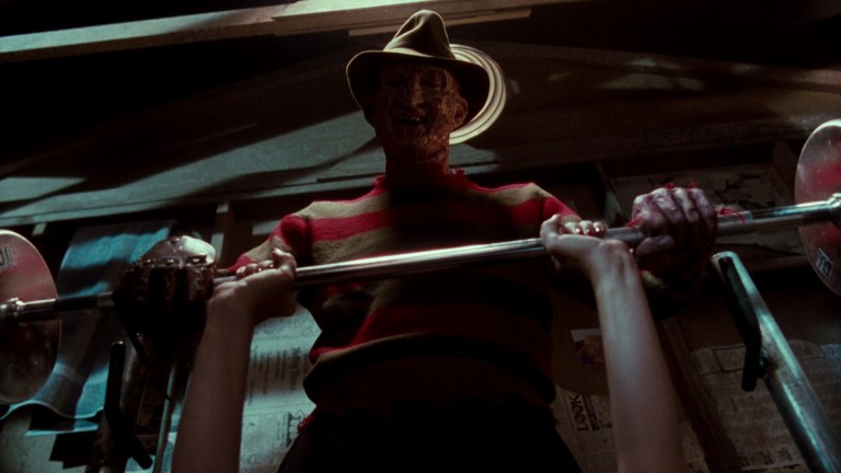 Freddy Krueger pushes down on a barbell in A Nightmare on Elm Street 4: The Dream Master (1988).