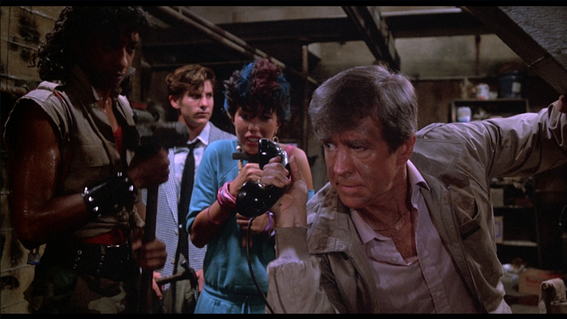 Burt holds up the phone so the punks can hear screaming in The Return of the Living Dead (1985).