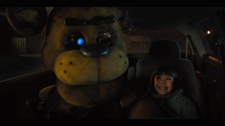 Abby smiles next to Freddy in the backseat of a car in Five Nights at Freddy's.