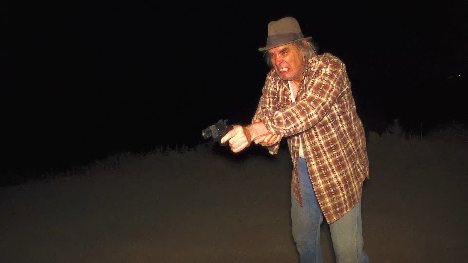 Greg holds a gun in Milk & Serial (2024).