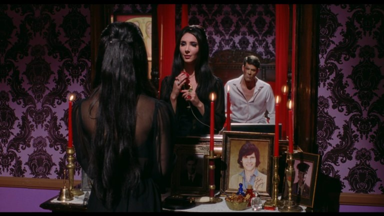 Griff watches as Elaine looks into a mirror in The Love Witch (2016).